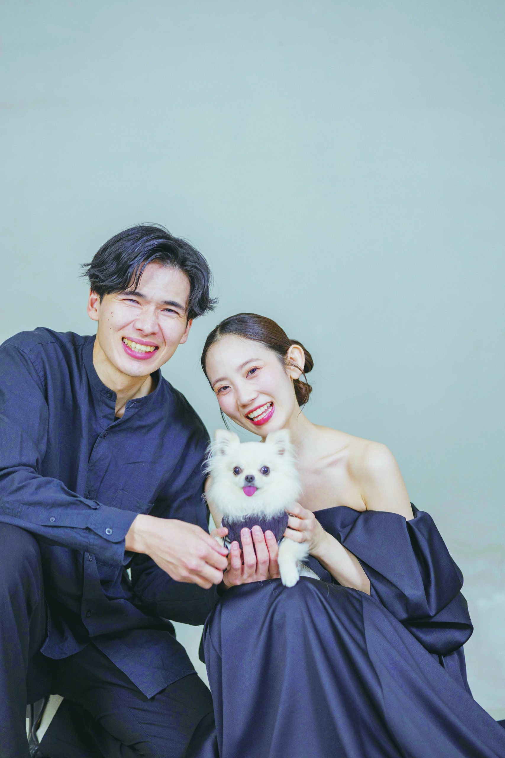 ネイビーの衣装で愛犬を抱くお二人